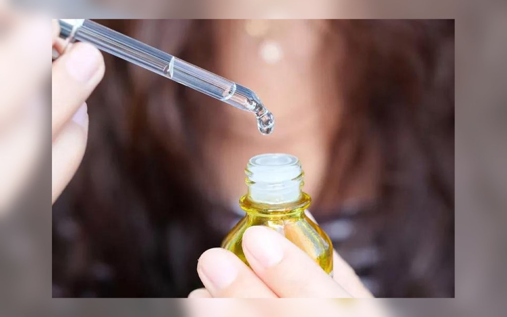 Person holding vitamin C serum with dropper